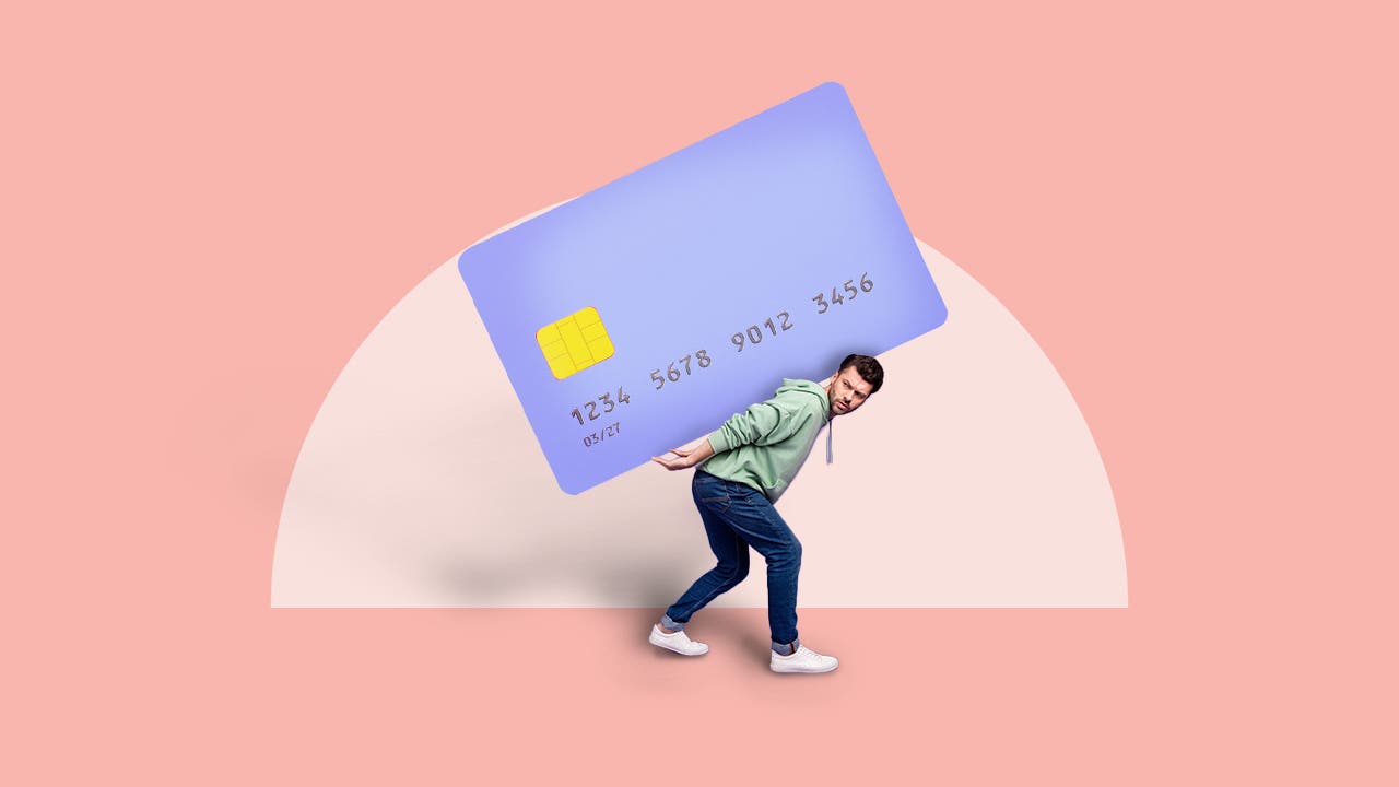 Man being weighed down with a credit card on his back.